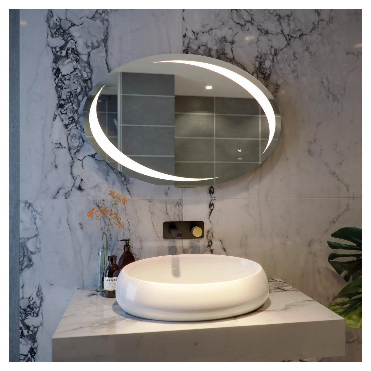 Sink with marble countertop and round vessel basin in a modern bathroom with marble wall and illuminated crescent mirror.