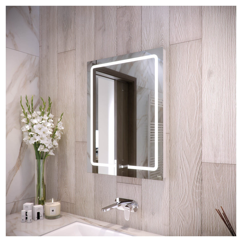 Modern illuminated bathroom mirror with LED lighting over marble and wood textured wall, sleek sink, and decorative flowers, showcasing contemporary bathroom design by Bubly Bathrooms.