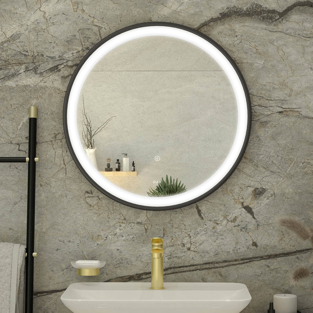 Sleek round illuminated bathroom mirror above white sink with gold fixtures in modern bathroom setting.