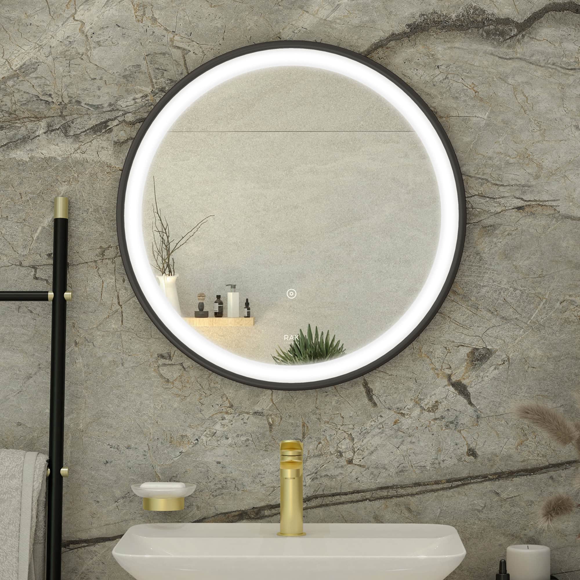 Sleek round illuminated bathroom mirror above white sink with gold fixtures in modern bathroom setting.