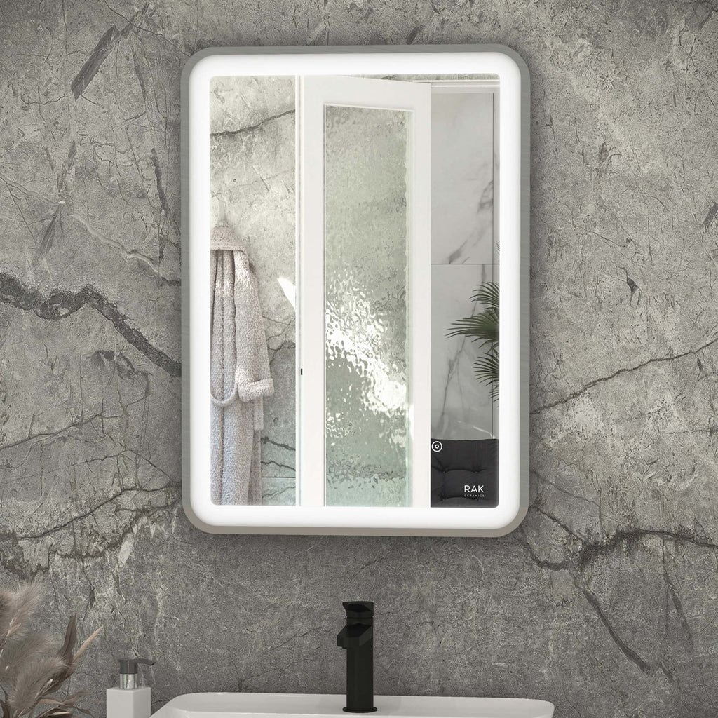 Sleek modern bathroom mirror with built-in LED lighting, framed in white, featuring a touch control panel for convenience, mounted on a stone-textured wall.