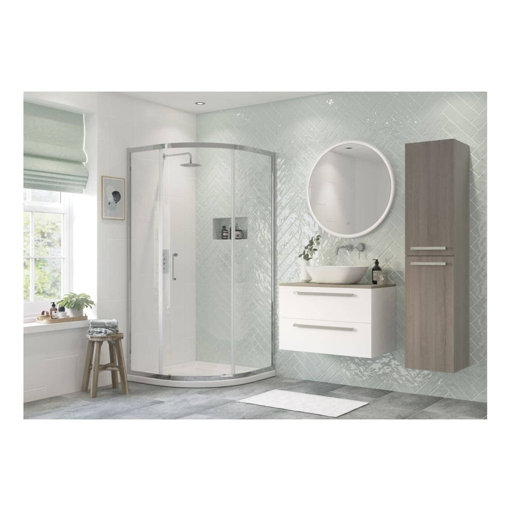Modern minimalist bathroom with walk-in shower, wall-mounted vanity, round mirror, and natural light, featuring contemporary fixtures and soft pastel wall tiles.