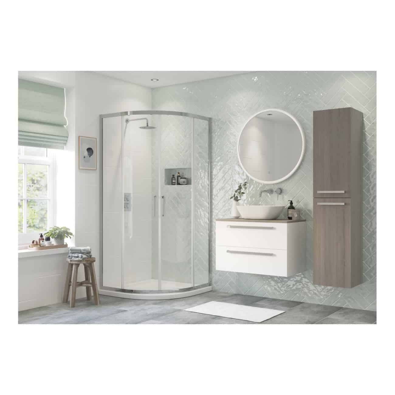Sleek modern bathroom with a tiled wall, corner shower enclosure, wall-mounted vanity with vessel sink, large round illuminated mirror, and natural light from a window, showcasing contemporary bathroom design.