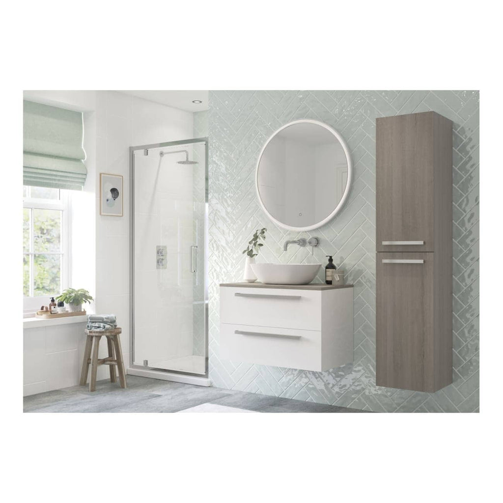 Modern bathroom with corner shower enclosure, contemporary vanity with vessel sink, round mirror with backlighting, wooden wall cabinet, large window with green Roman blind, and soft grey floor mat, showcasing stylish and functional bathroom design.