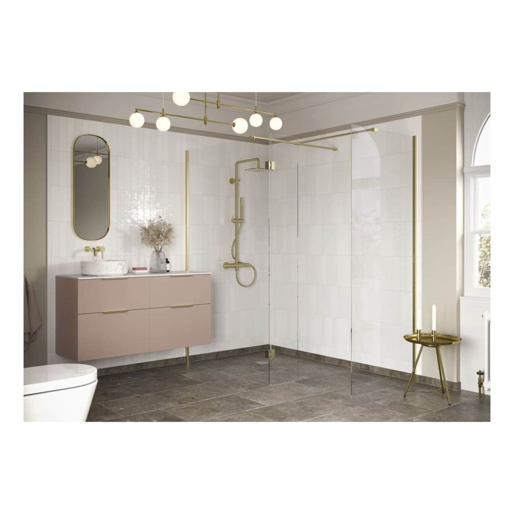 Bright modern bathroom with a beige floating vanity, round mirror, gold fixtures, and walk-in shower with clear glass partition in a stylish minimalistic design.