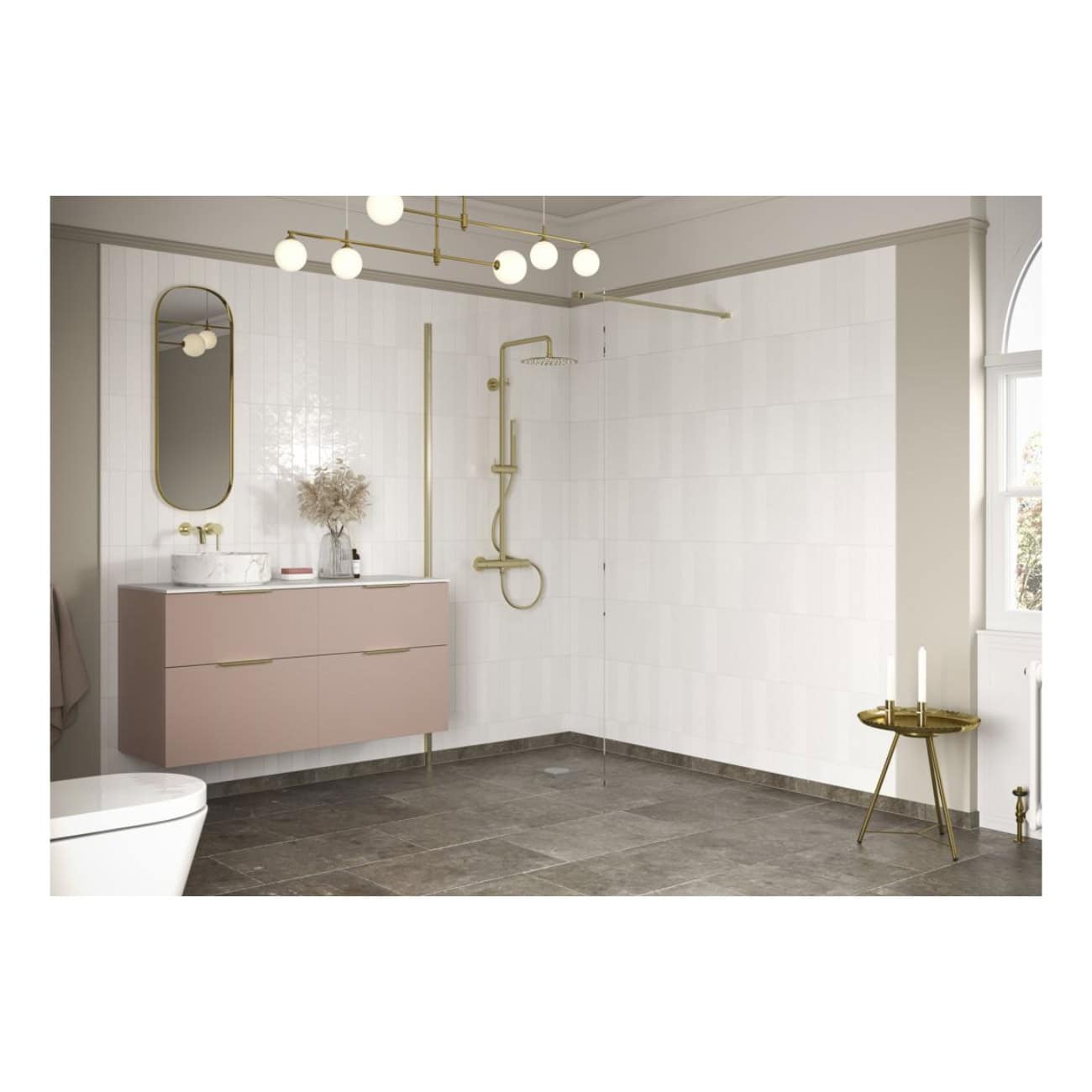 Light pink floating bathroom vanity with marble countertop, modern oval mirror, gold fixtures, minimalist shower with gold hand shower, decorative side table with candles, large window, neutral tile flooring, stylish and contemporary bathroom design.
