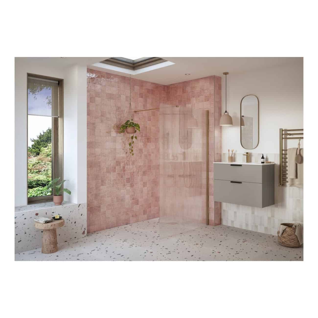 Vibrant pink tiled walk-in shower in modern bathroom with terrazzo flooring, grey vanity unit, and lush greenery through large window. Stylish, contemporary bathroom design by Bubly Bathrooms.
