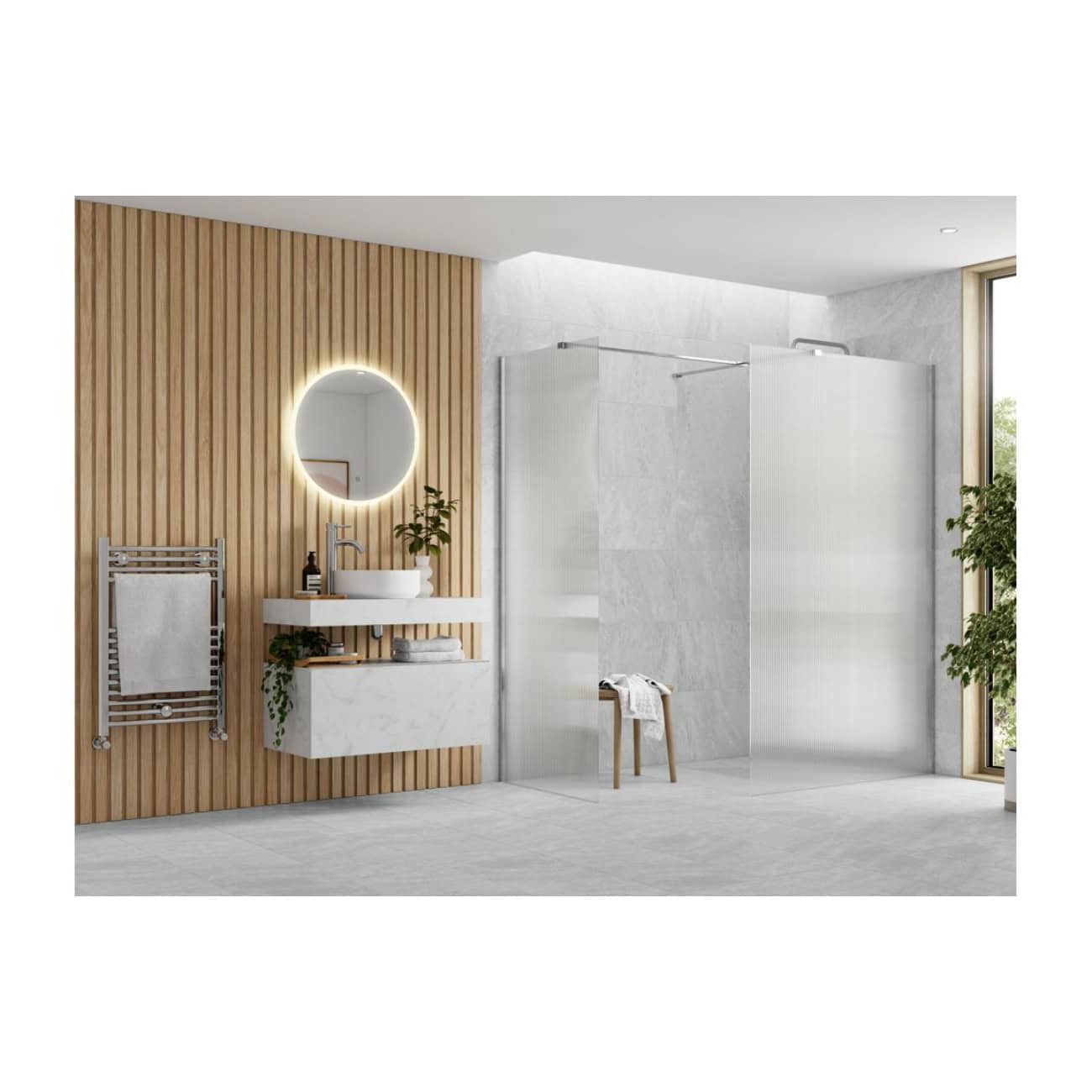 Bright modern bathroom with a wooden slat feature wall, illuminated round mirror, white floating sink, and a spacious walk-in shower with glass panels, complemented by green indoor plants.
