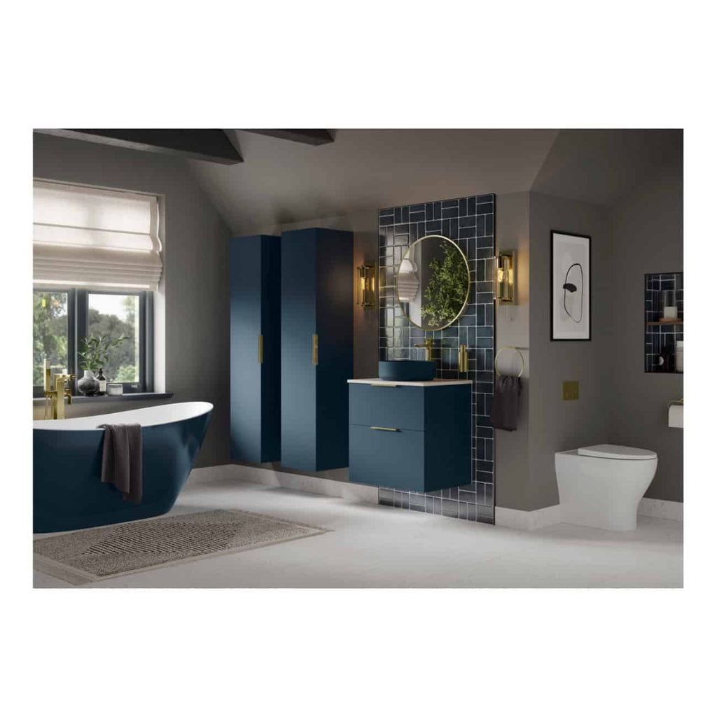 Stylish modern bathroom with navy blue bathtub, matching vanity, grey walls, gold fixtures, black tiled wall with oval mirror, and contemporary decor accents.