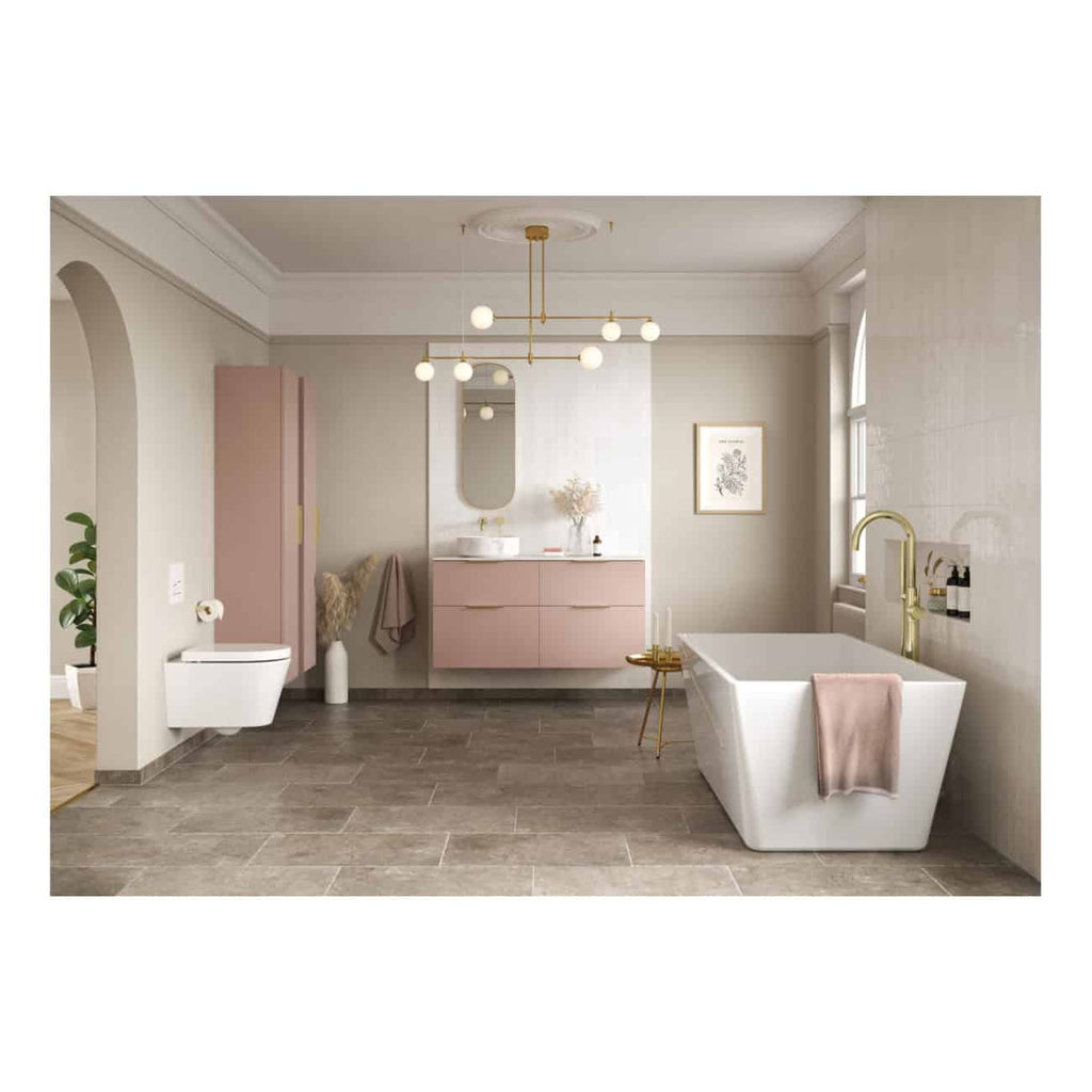 Luxurious bathroom with freestanding bathtub, modern pink vanity unit, wall-mounted toilet, gold fixtures, stylish decor, natural light, and contemporary design by Bubly Bathrooms.