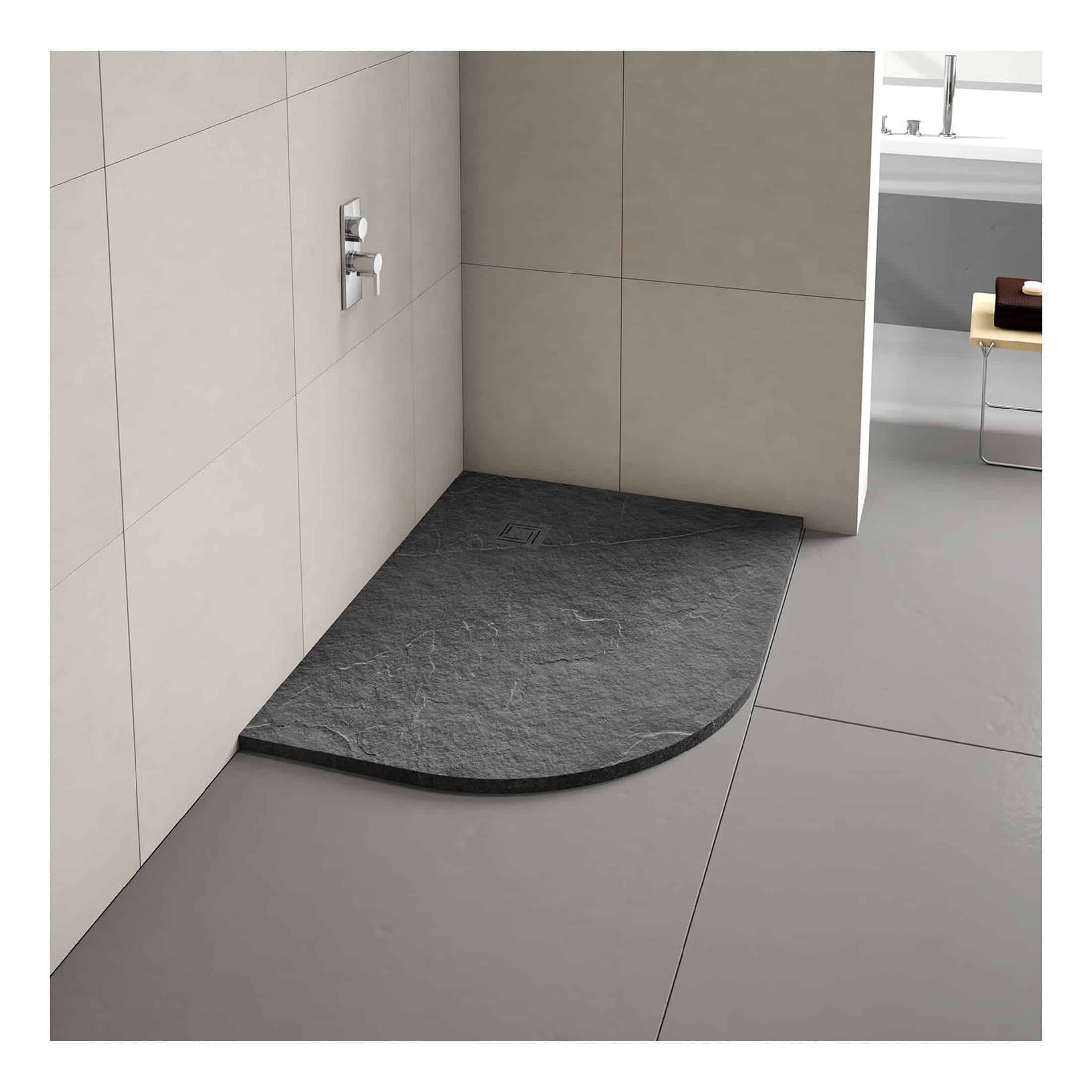 Polished black stone shower tray in modern bathroom with neutral coloured tiles and contemporary fixtures, perfect for stylish shower room renovations.