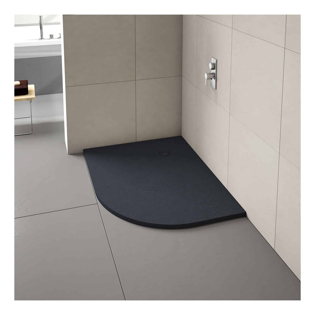 Modern black shower tray with curved edge, designed for stylish bathroom shower areas, featuring a central drain and minimalist wall-mounted controls.