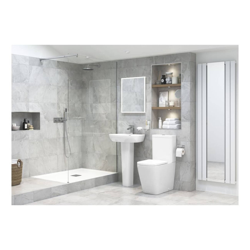 Sleek modern bathroom with walk-in shower, white toilet, pedestal sink, large mirror, and built-in shelving featuring bathroom essentials, in neutral grey tones for contemporary bathroom design.