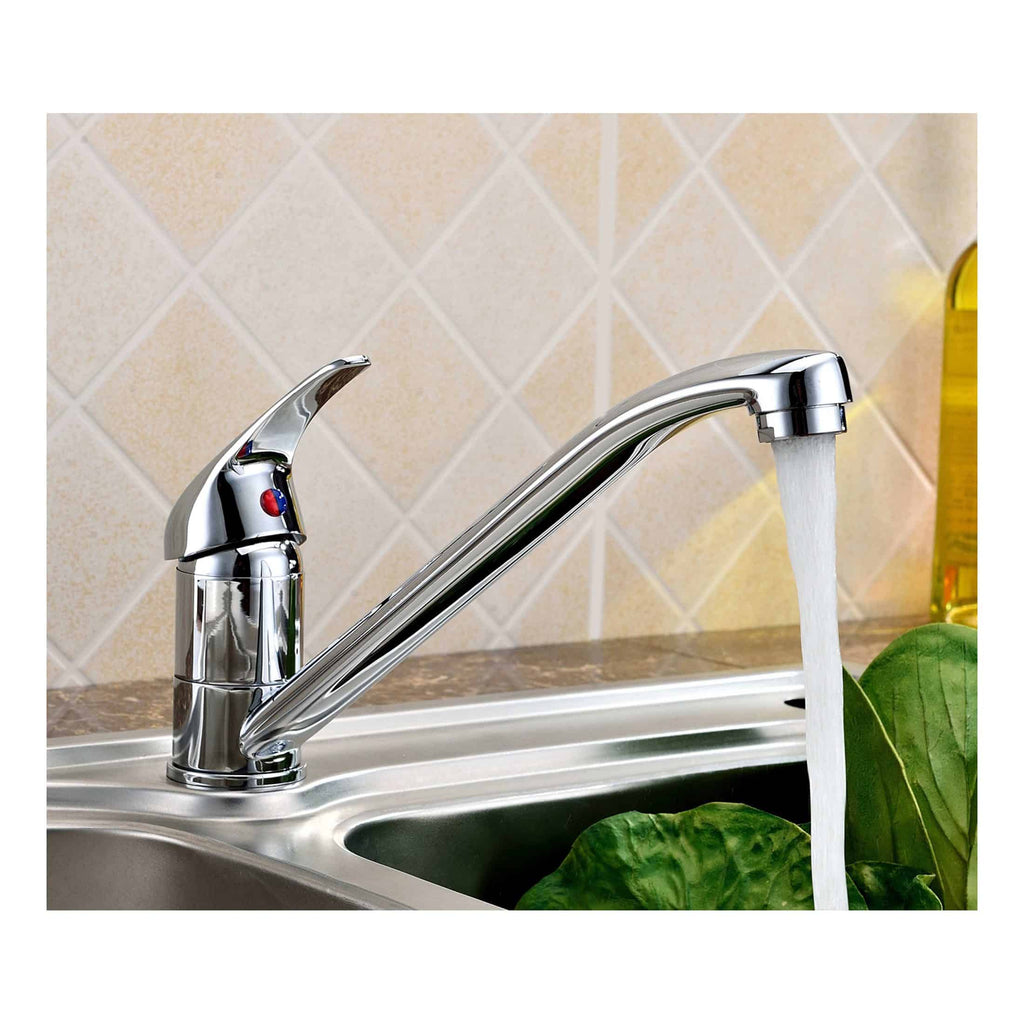 Shiny chrome kitchen sink mixer tap flowing water in a modern kitchen, with beige tiled wall and green leafy plant for a fresh, hygienic kitchen environment.