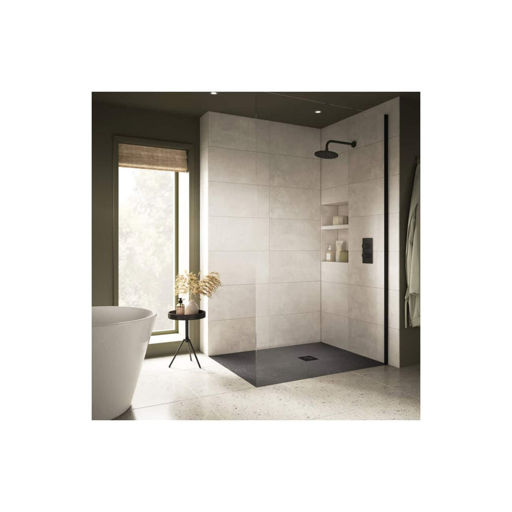 Minimalist walk-in shower with black fixtures and built-in shelves in a modern bathroom, featuring neutral tiles, a freestanding bathtub, and natural light from a large window.
