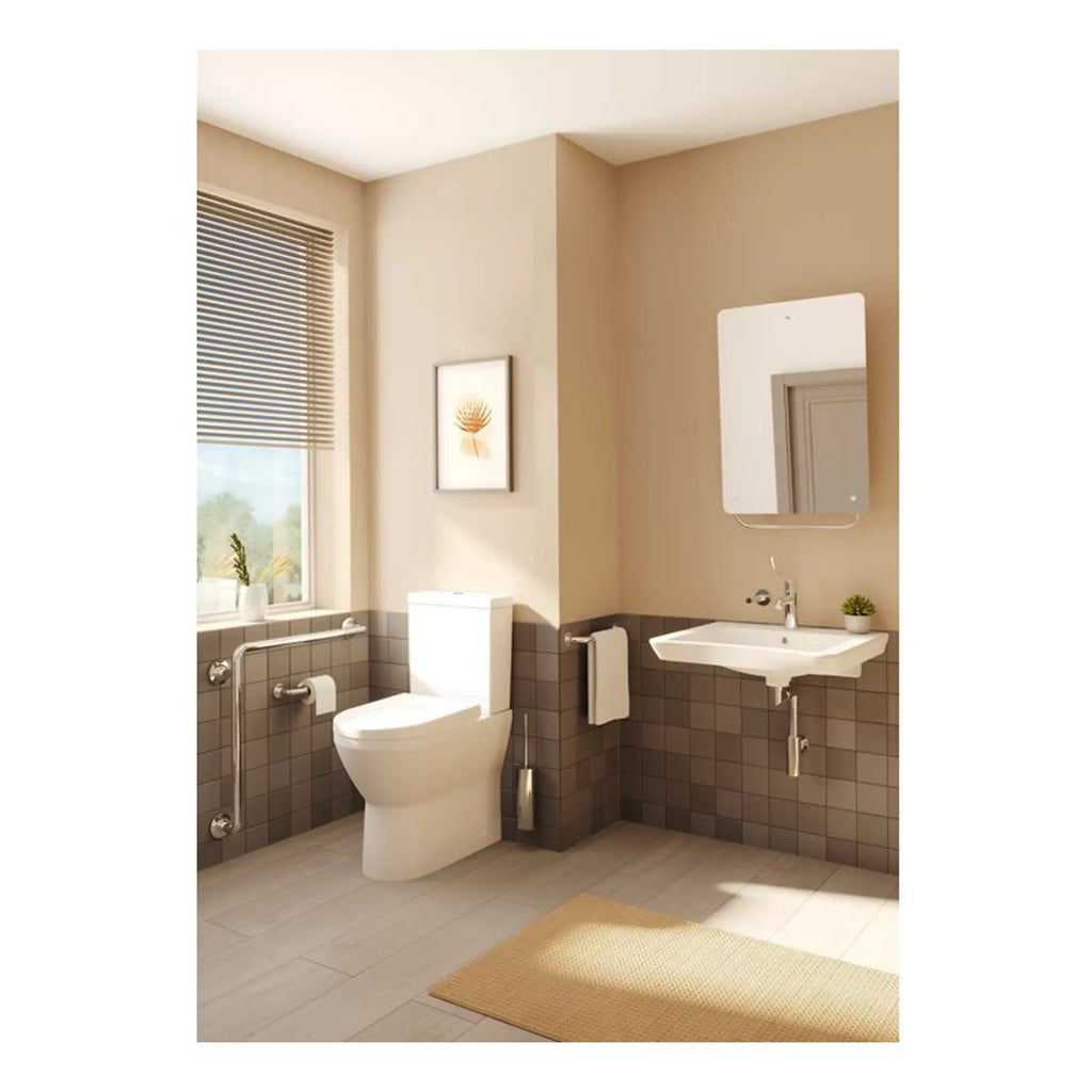 Contemporary accessible bathroom with beige walls, a white toilet with grab rails, a wall-mounted sink, and a large mirror, designed for comfort and usability.