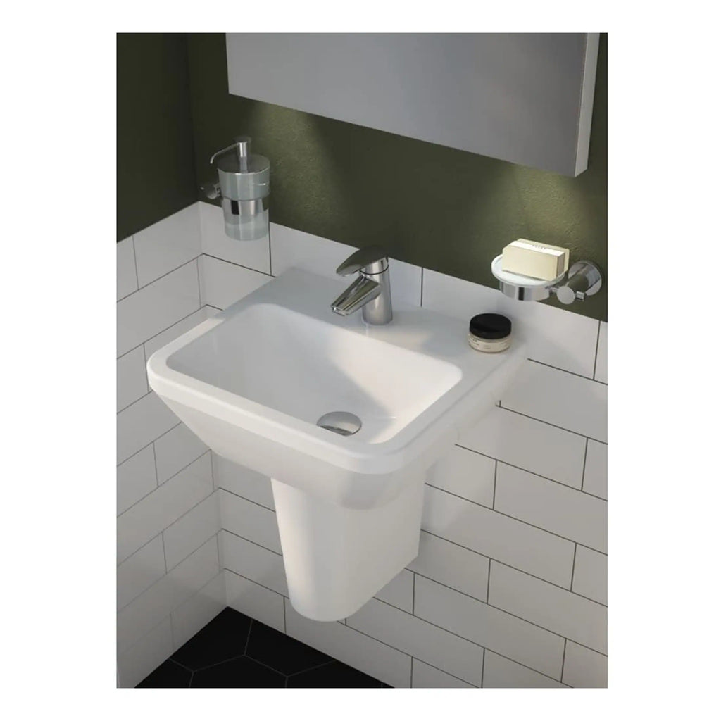 Polished white bathroom sink with sleek chrome tap, mounted on a tiled wall, complemented by a soap dispenser and toiletries holder, designed for modern bathroom spaces.