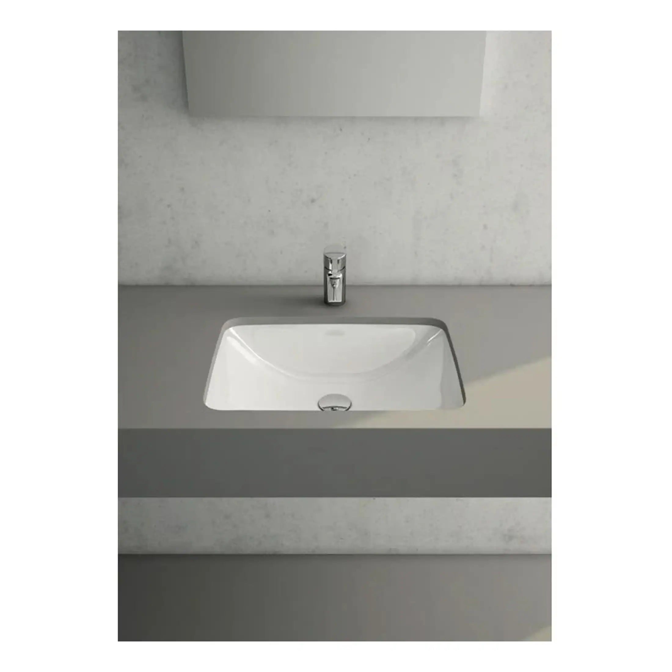Contemporary white bathroom sink with a sleek chrome tap set against a minimalist grey vanity unit and textured wall background.