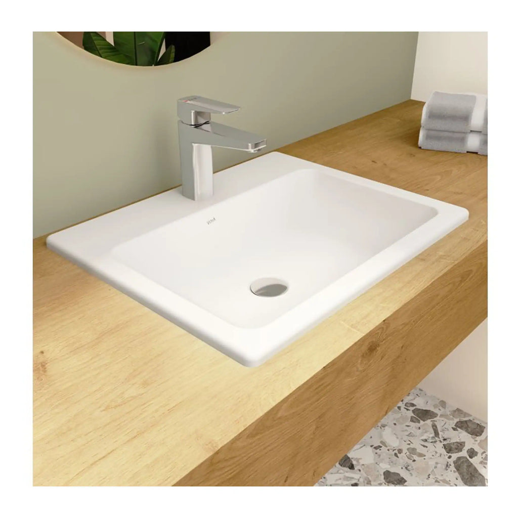 Modern white ceramic bathroom sink with a sleek chrome faucet on a wooden vanity countertop in a contemporary bathroom setting.