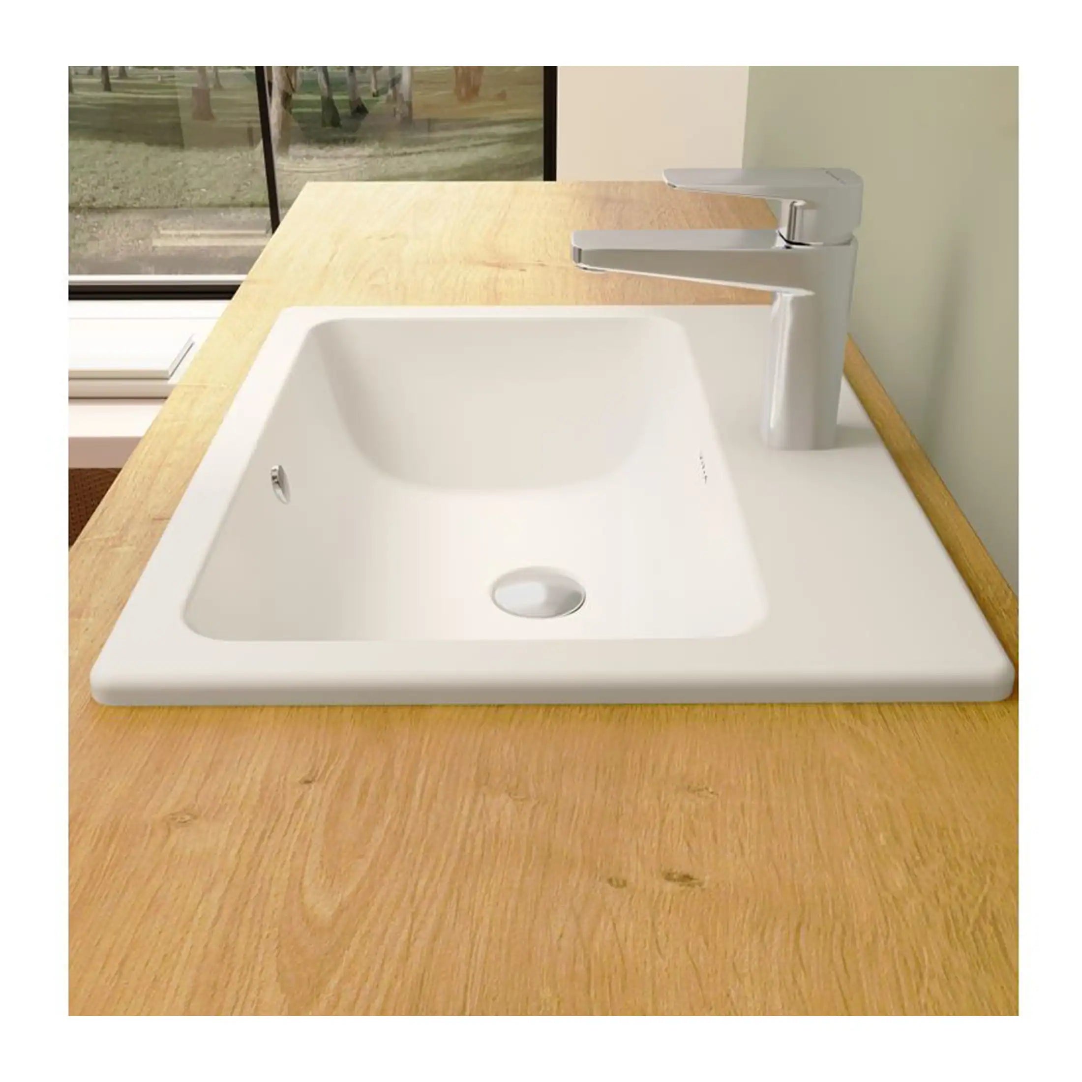 Sleek white kitchen sink with modern chrome tap on a wooden countertop, ideal for contemporary bathrooms or kitchens, showcasing durability and style.