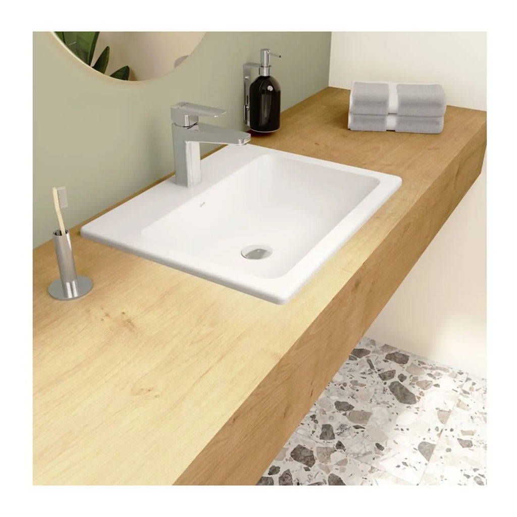 Bright modern bathroom sink with a wooden countertop, featuring a sleek chrome faucet, soap dispenser, and neatly folded towels, designed for contemporary bathroom decor.