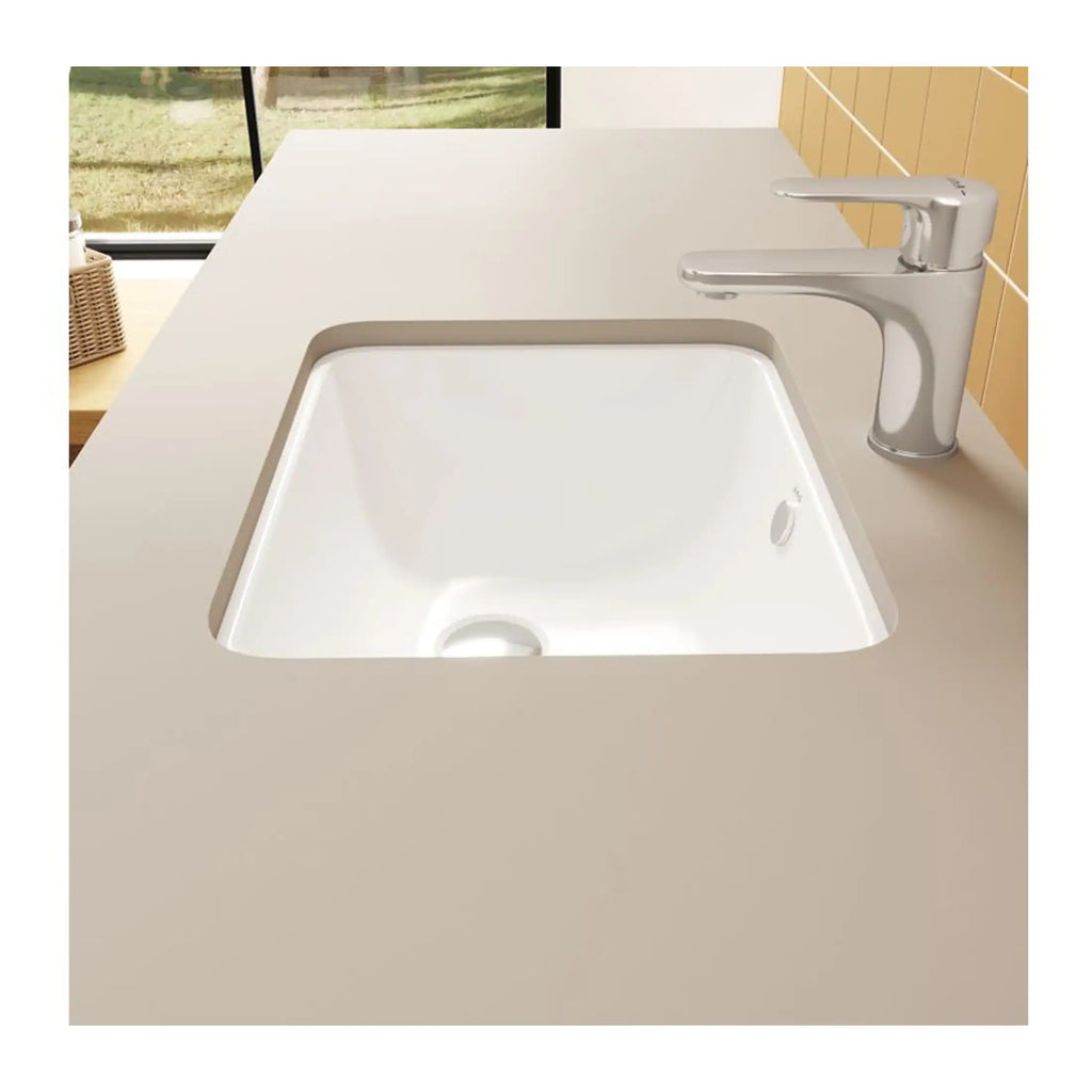 Sleek white kitchen sink with modern chrome tap in a contemporary kitchen setting, featuring a beige countertop and large window, perfect for modern bathroom and kitchen renovations.