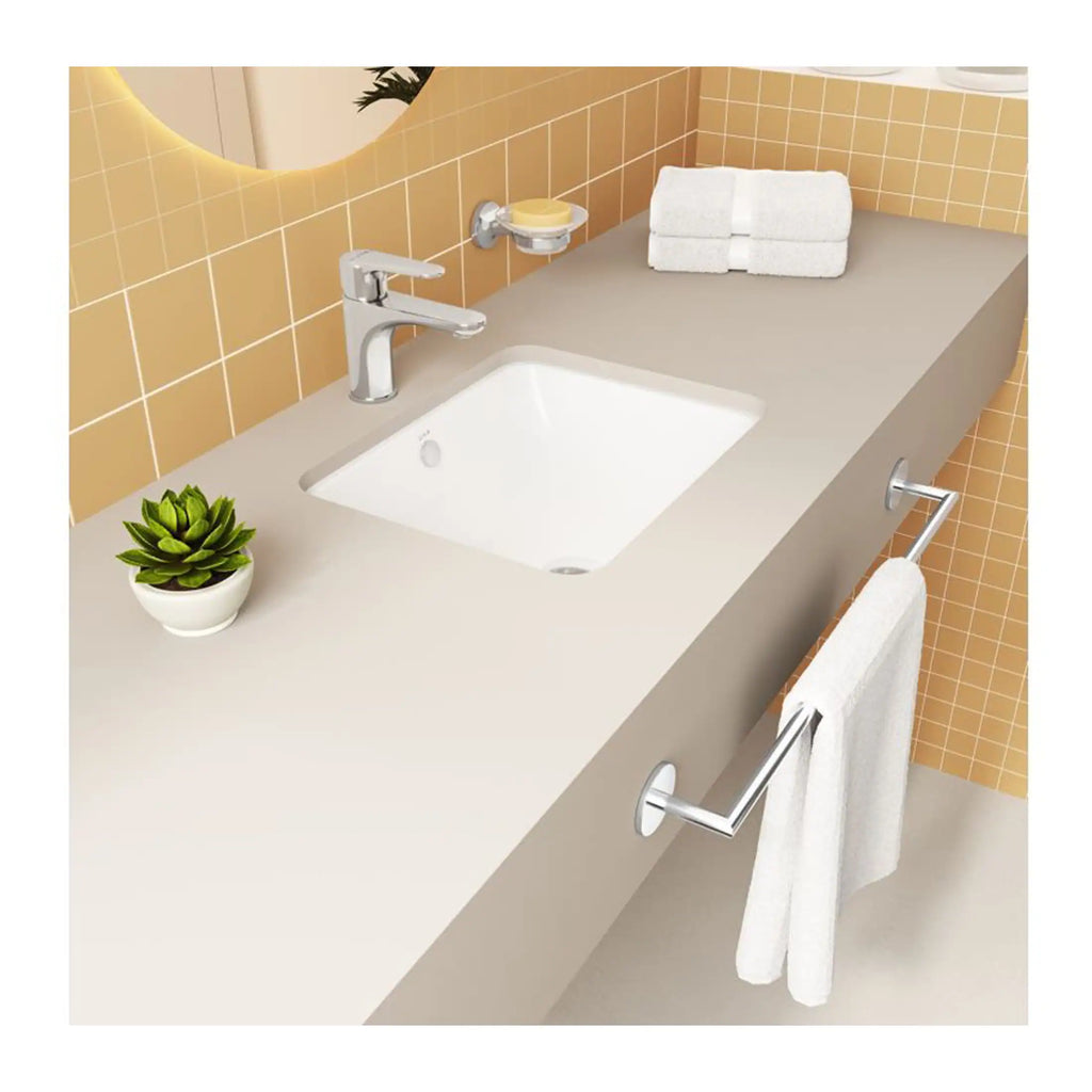 Shower wash basin with modern chrome tap, white towel on a rail, beige countertop, yellow tiled wall, and decorative plant for stylish bathroom decor.