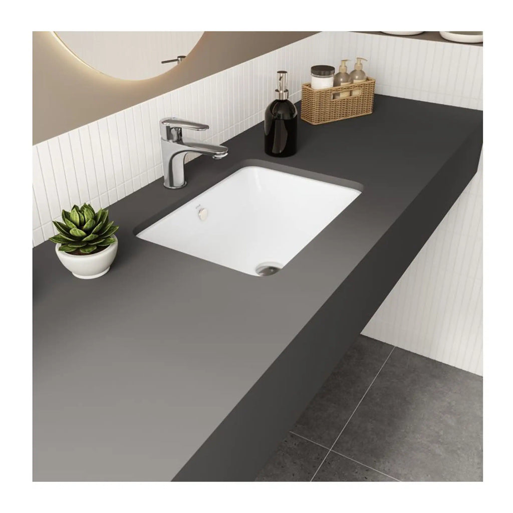 Sleek modern bathroom vanity with a black countertop, white undermount sink, chrome tap, and stylish accessories, perfect for contemporary bathroom design.