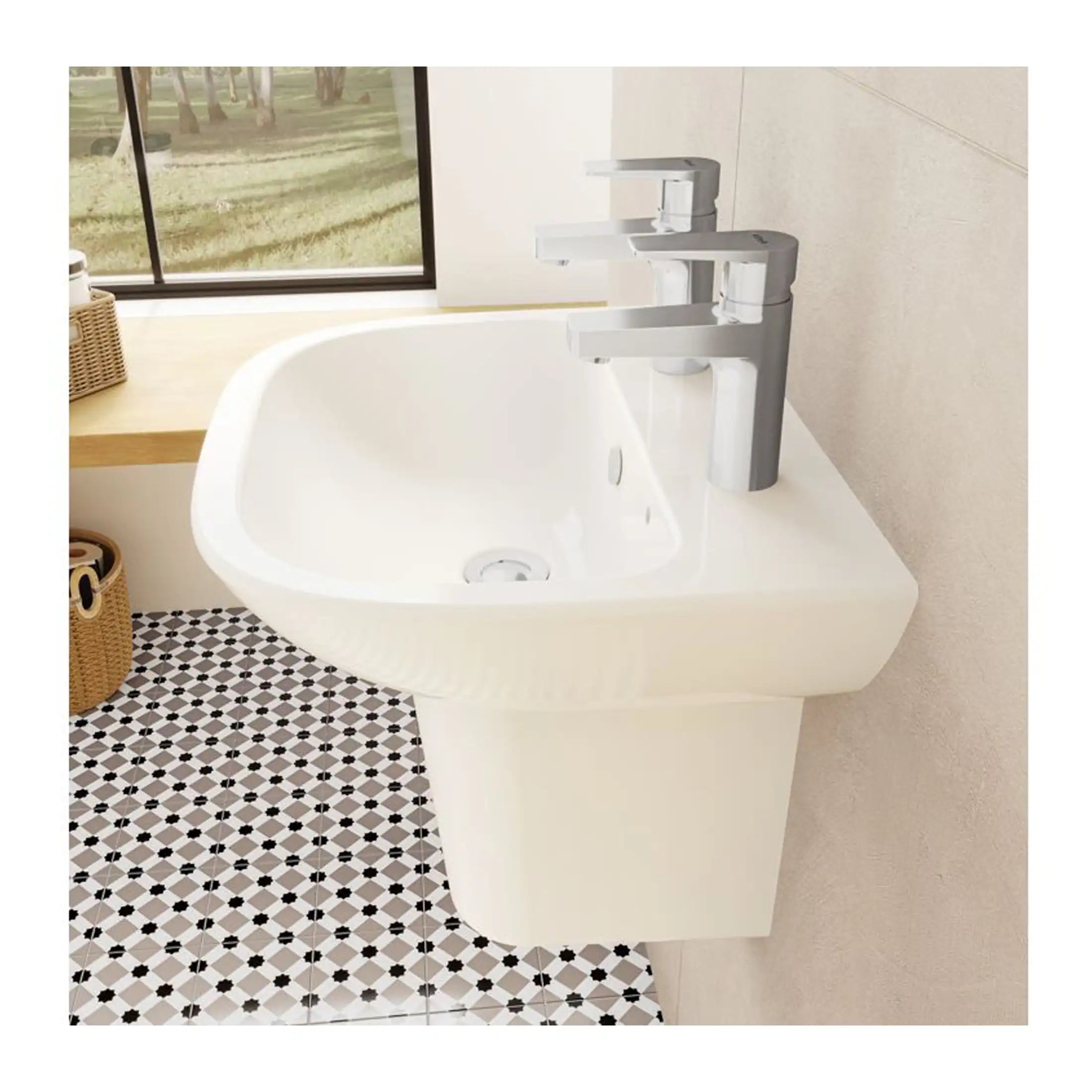 Shiny white bathroom sink with dual modern chrome taps and a black-and-white geometric tiled floor, set against a beige wall next to a large window with a scenic outdoor view.