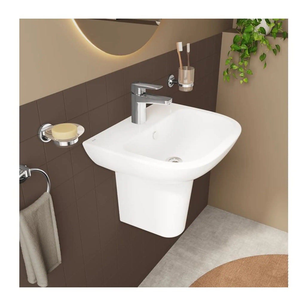 Sleek white wall-mounted bathroom sink with chrome faucet, surrounded by modern accessories and a decorative green plant, creating a stylish and functional bathroom space.
