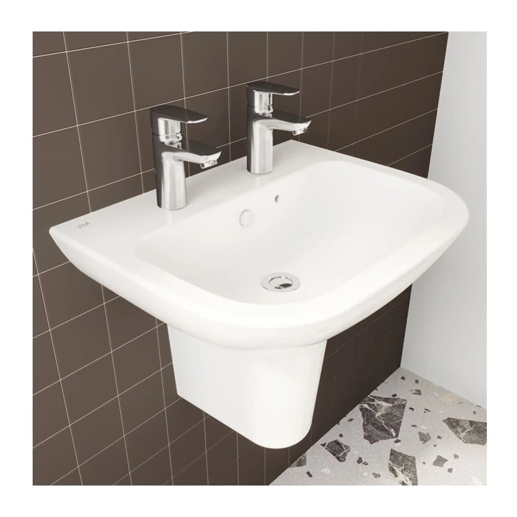 Modern white bathroom sink with dual chrome taps, wall-mounted design, set against a brown tiled wall with a terrazzo floor, ideal for contemporary bathroom decor.