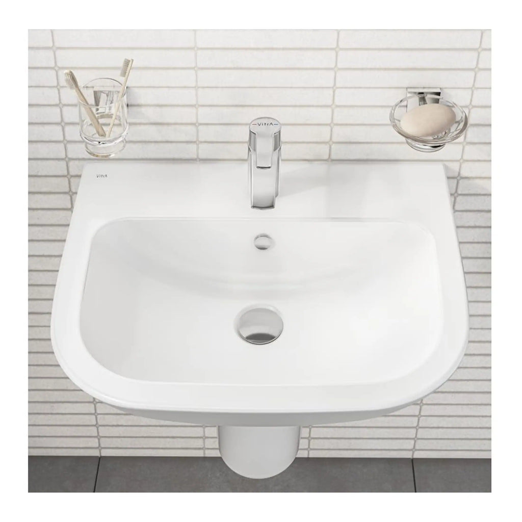 Shiny white wall-mounted bathroom sink with modern chrome tap and minimalistic accessories, featuring toothbrush holder and soap dish, ideal for contemporary bathroom design.