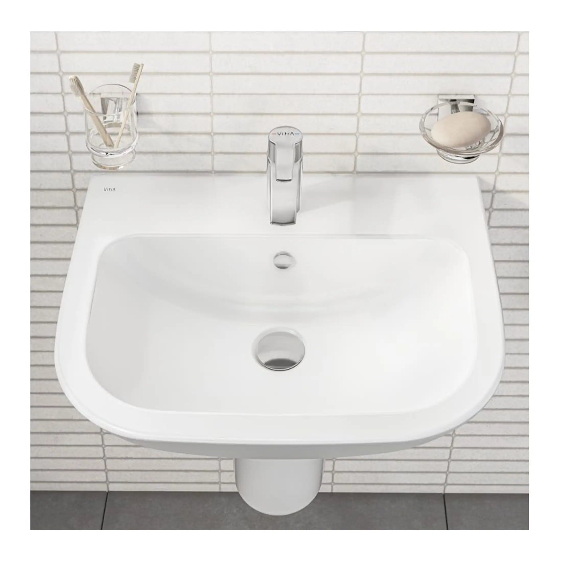 Shiny white wall-mounted bathroom sink with modern chrome tap and minimalistic accessories, featuring toothbrush holder and soap dish, ideal for contemporary bathroom design.