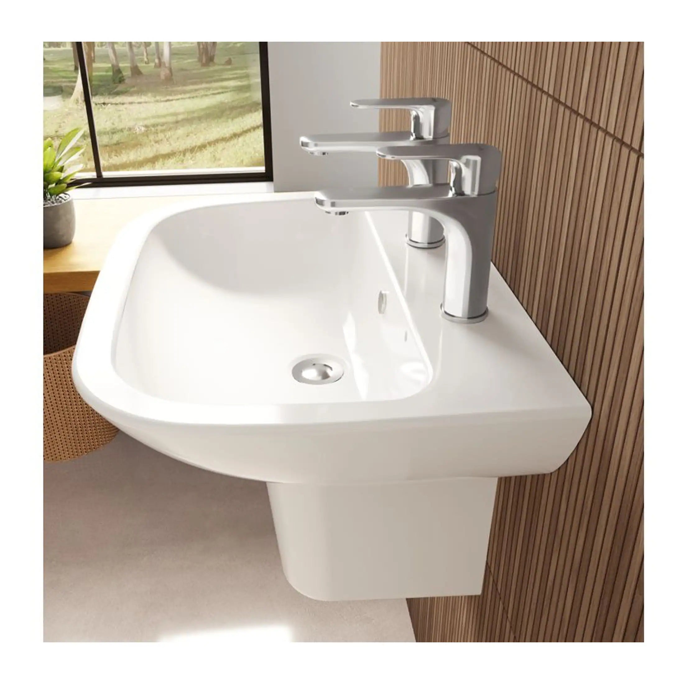 Sleek modern white bathroom sink with dual faucets and chrome fittings, set against a wooden wall with a window view of greenery, ideal for contemporary bathroom designs.