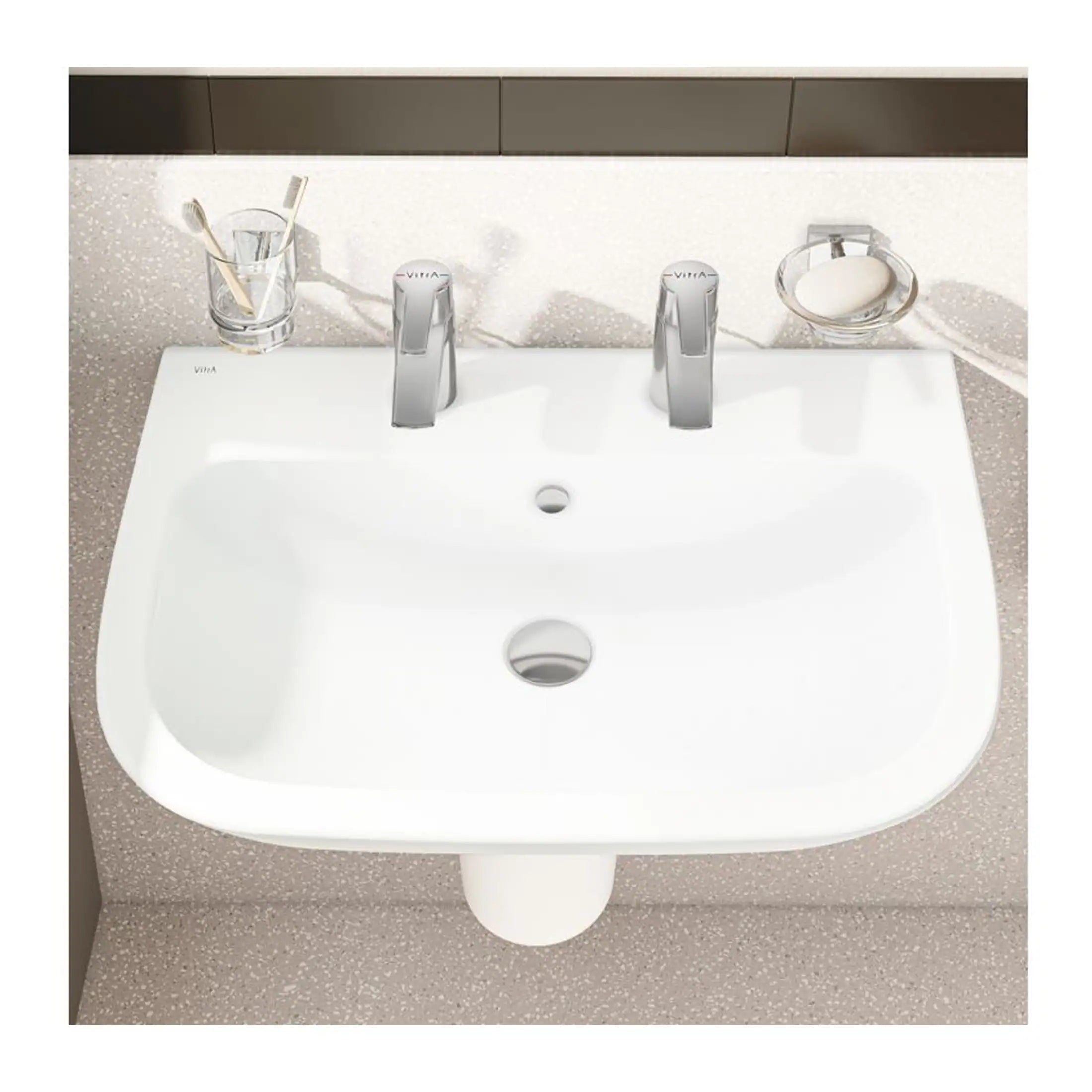 Contemporary white bathroom sink with dual modern chrome faucets, elegant glass toothbrush holder, and soap dish, designed for stylish and functional bathroom decorating.