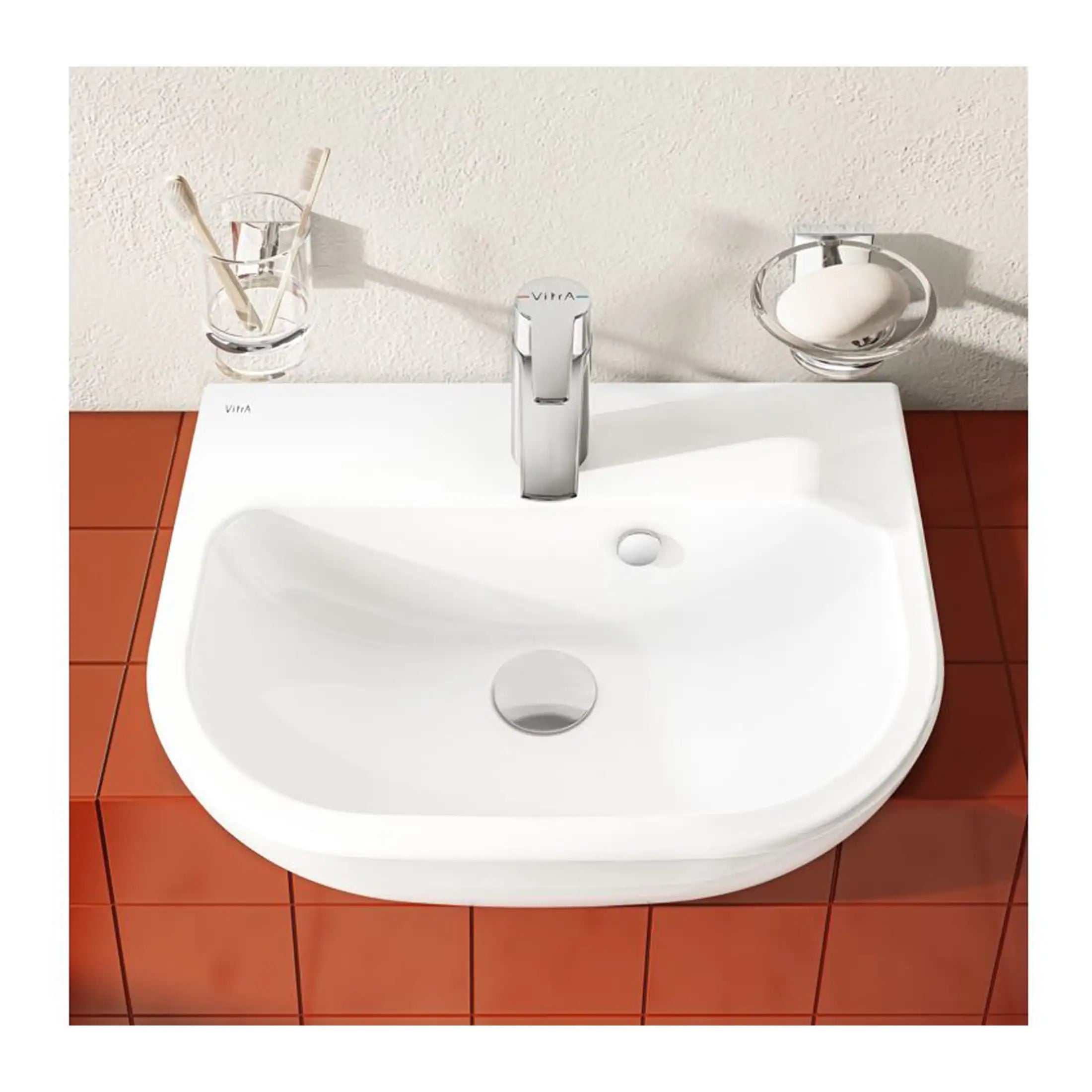 Sleek white bathroom sink with modern chrome tap, mounted on a terracotta tiled countertop, featuring minimalistic design perfect for contemporary bathroom interiors.