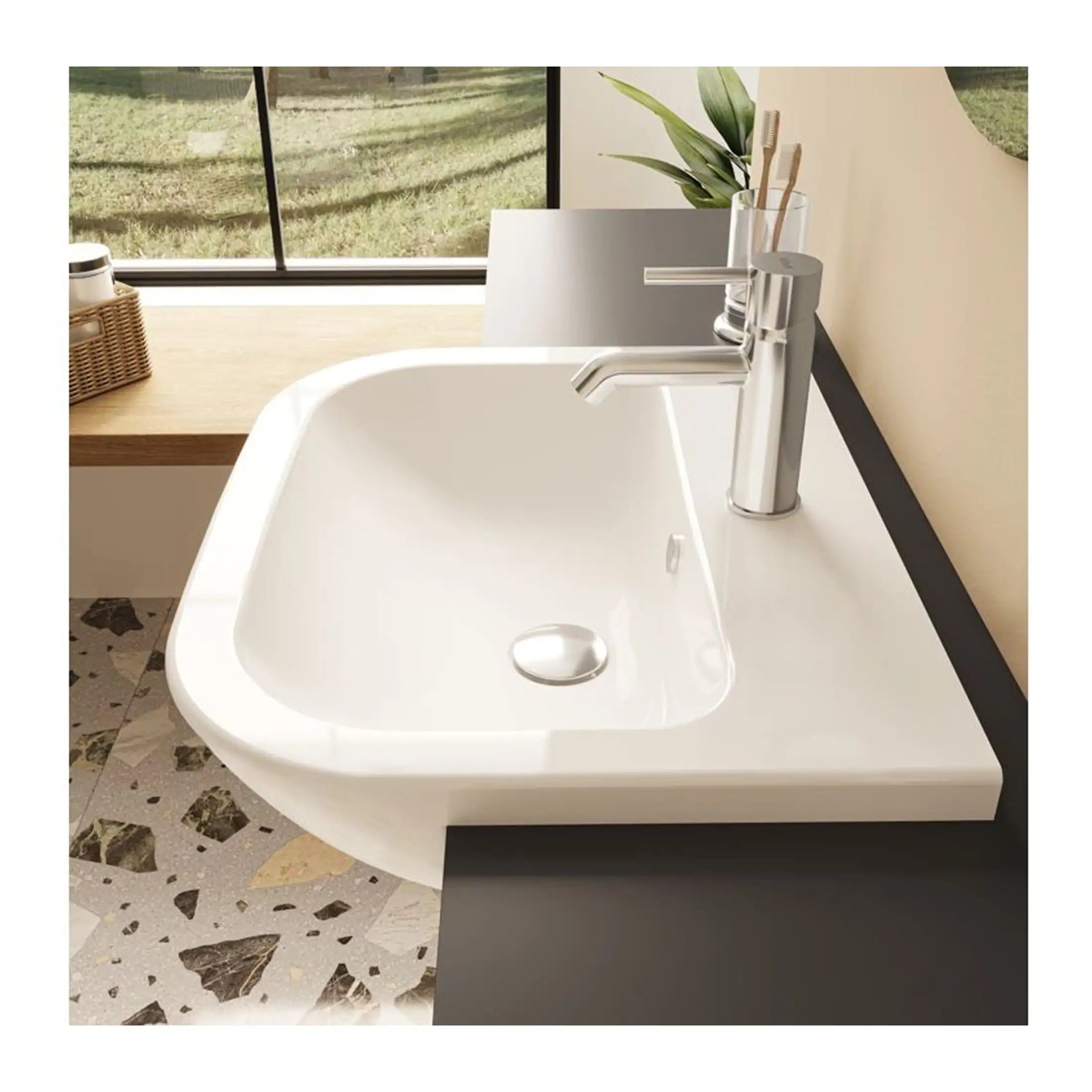 Close-up of a modern white sink with a sleek chrome tap, set in a contemporary bathroom featuring terrazzo flooring and a large window with natural light.