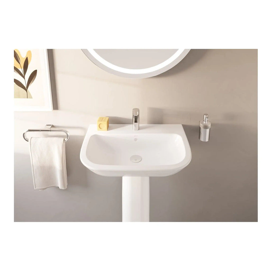 Sleek modern bathroom sink with chrome tap, mounted on a white pedestal, featuring a wall-mounted soap dispenser and towel rail, part of Bubly Bathrooms' stylish and functional bathroom designs.