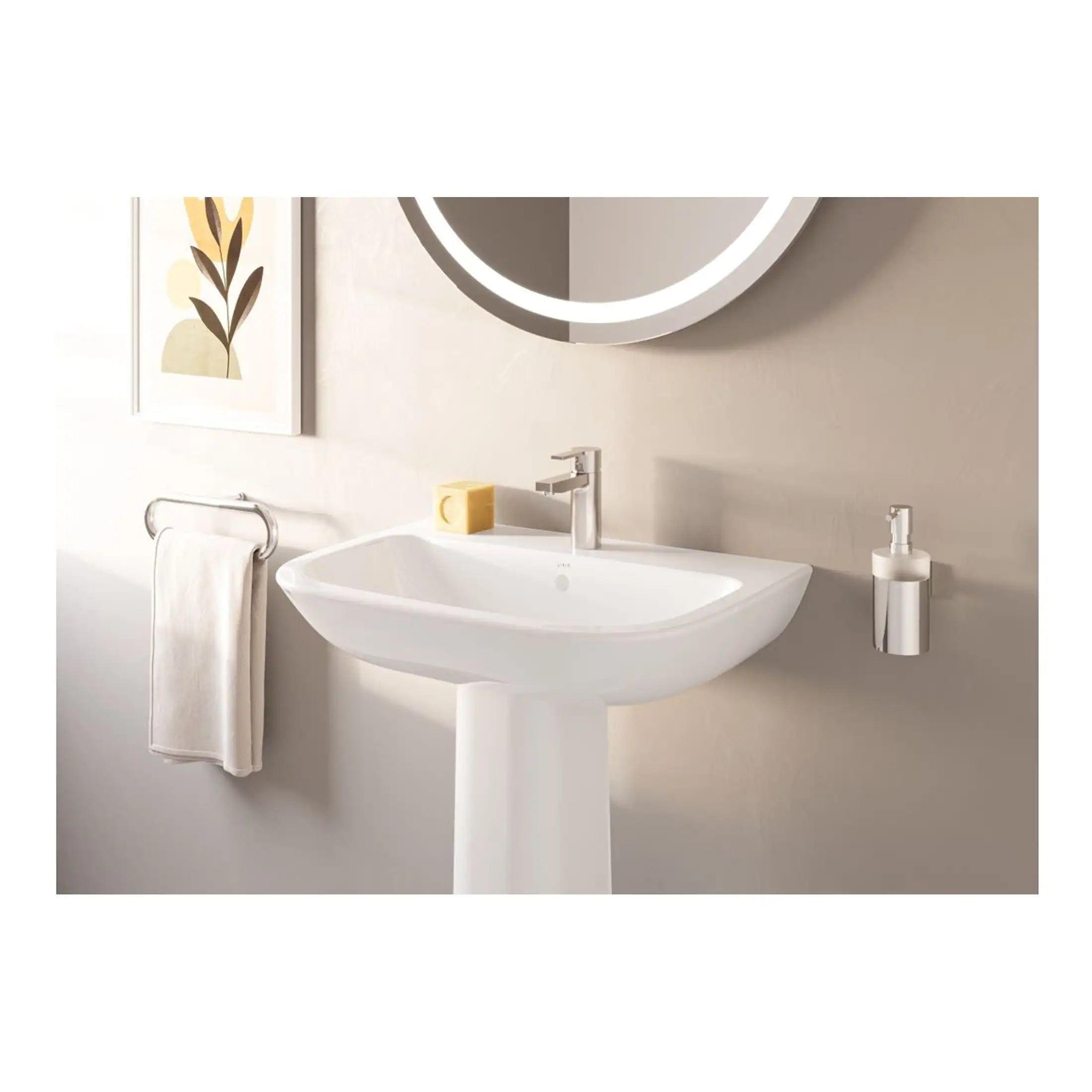 Contemporary white pedestal bathroom sink with modern chrome faucet, wall-mounted soap dispenser, and soft beige wall featuring abstract artwork in a sleek bathroom setting.