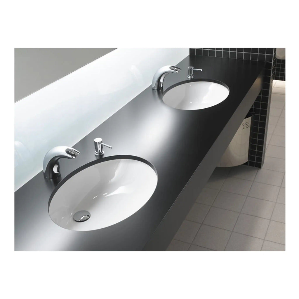 Sleek black countertop with two integrated white ceramic sinks and modern chrome faucets in a contemporary bathroom setting. Designed for functionality and style, ideal for commercial or high-traffic facilities.