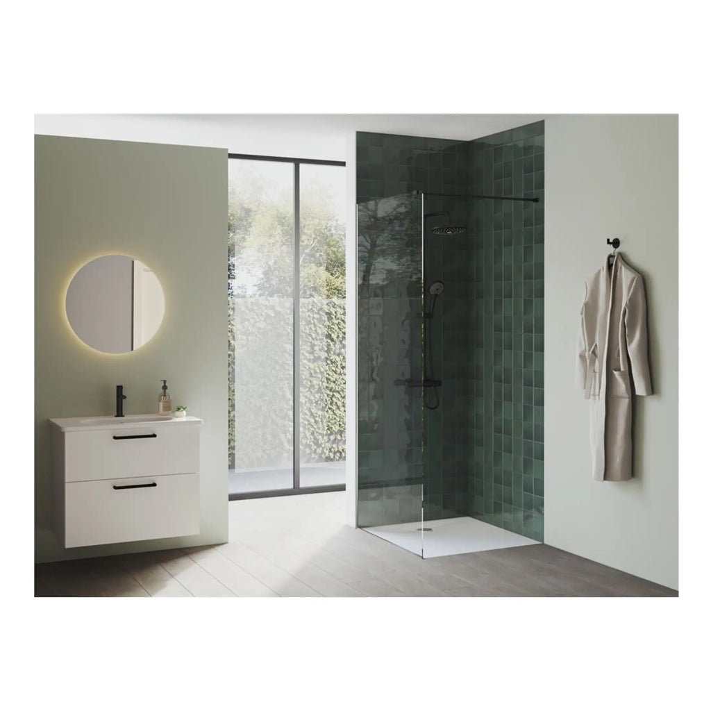 Modern minimalist bathroom with sleek white vanity, illuminated round mirror, walk-in shower with green tiles, and a large window bringing in natural light, designed by Bubly Bathrooms.