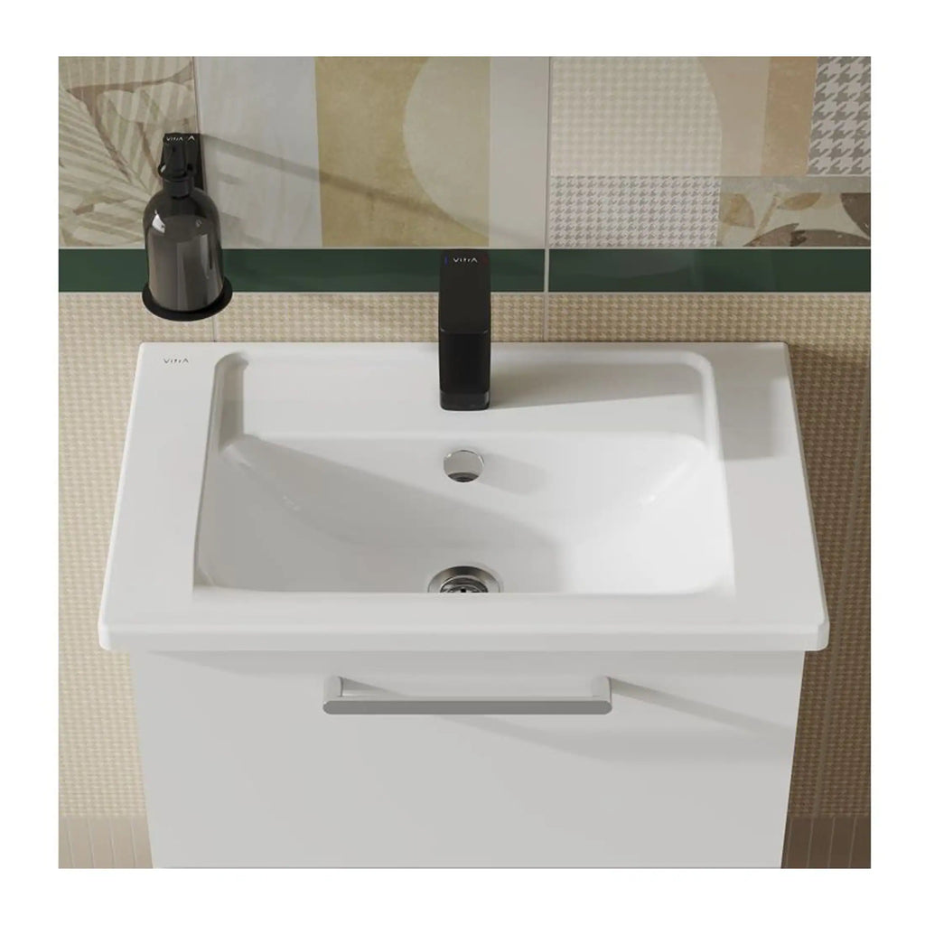Sleek white bathroom sink with black tap and wall-mounted soap dispenser, modern design, ideal for contemporary bathrooms, featuring durable materials and a clean, minimalist aesthetic.