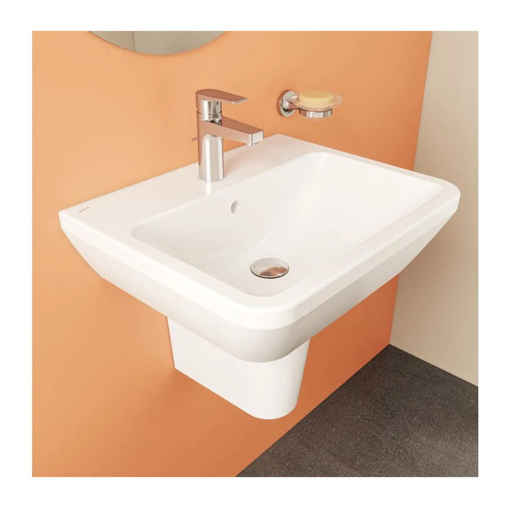 Sleek white wall-mounted bathroom sink with chrome faucet and soap dish, set against a pastel orange wall, perfect for modern bathroom decor.