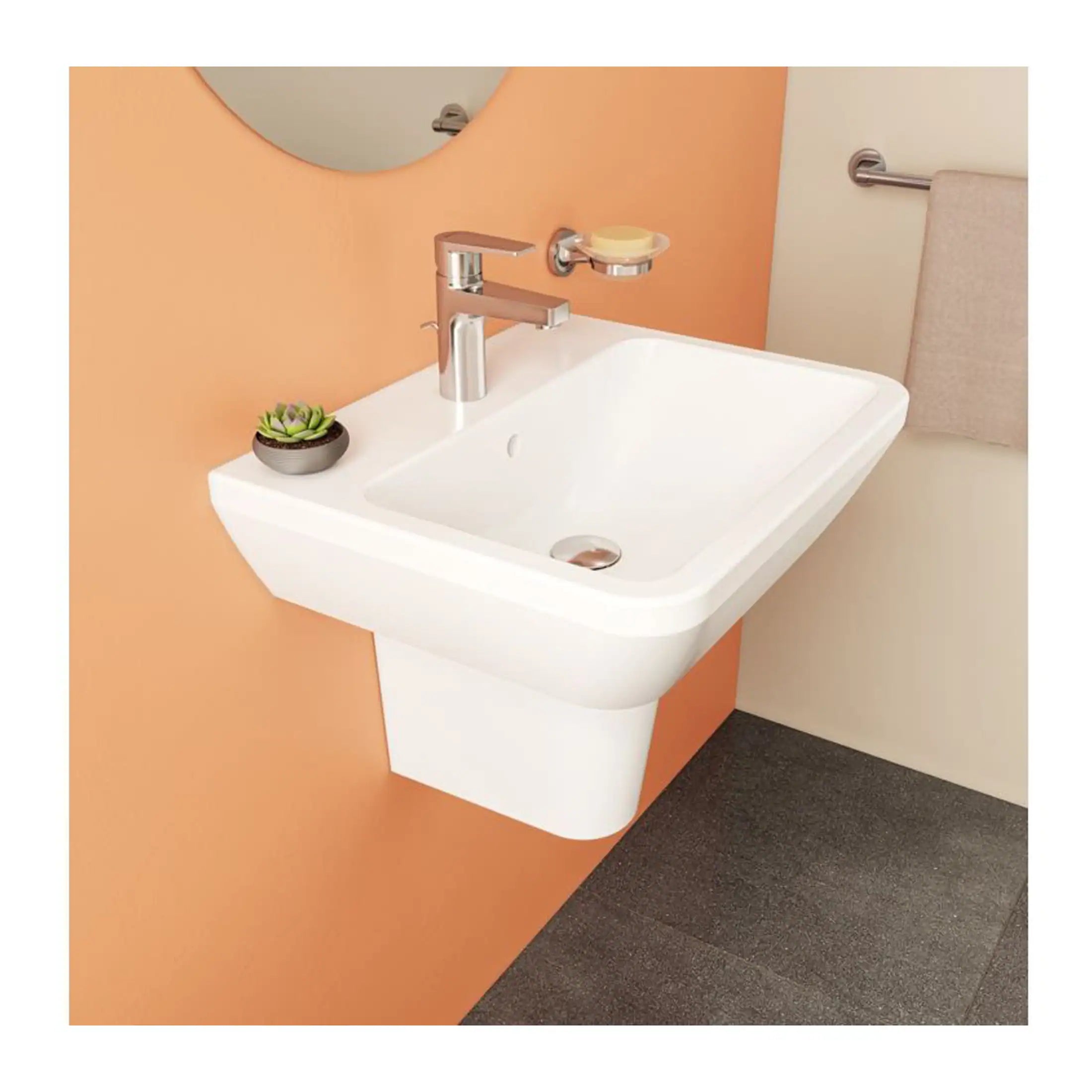 Sleek modern wall-mounted white bathroom sink with chrome faucet, small decorative plant, soap dish, beige wall, towel rail, and dark flooring, ideal for contemporary bathroom design.
