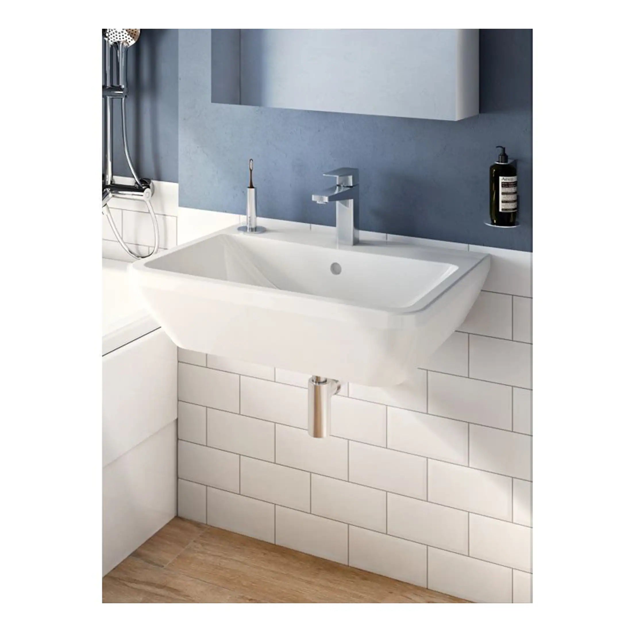 Modern white wall-mounted bathroom sink with a chrome faucet and a minimalist design, set against a stylish blue wall with white tiled lower section. Includes an integrated soap dispenser and reflection in mirror, perfect for contemporary bathrooms.