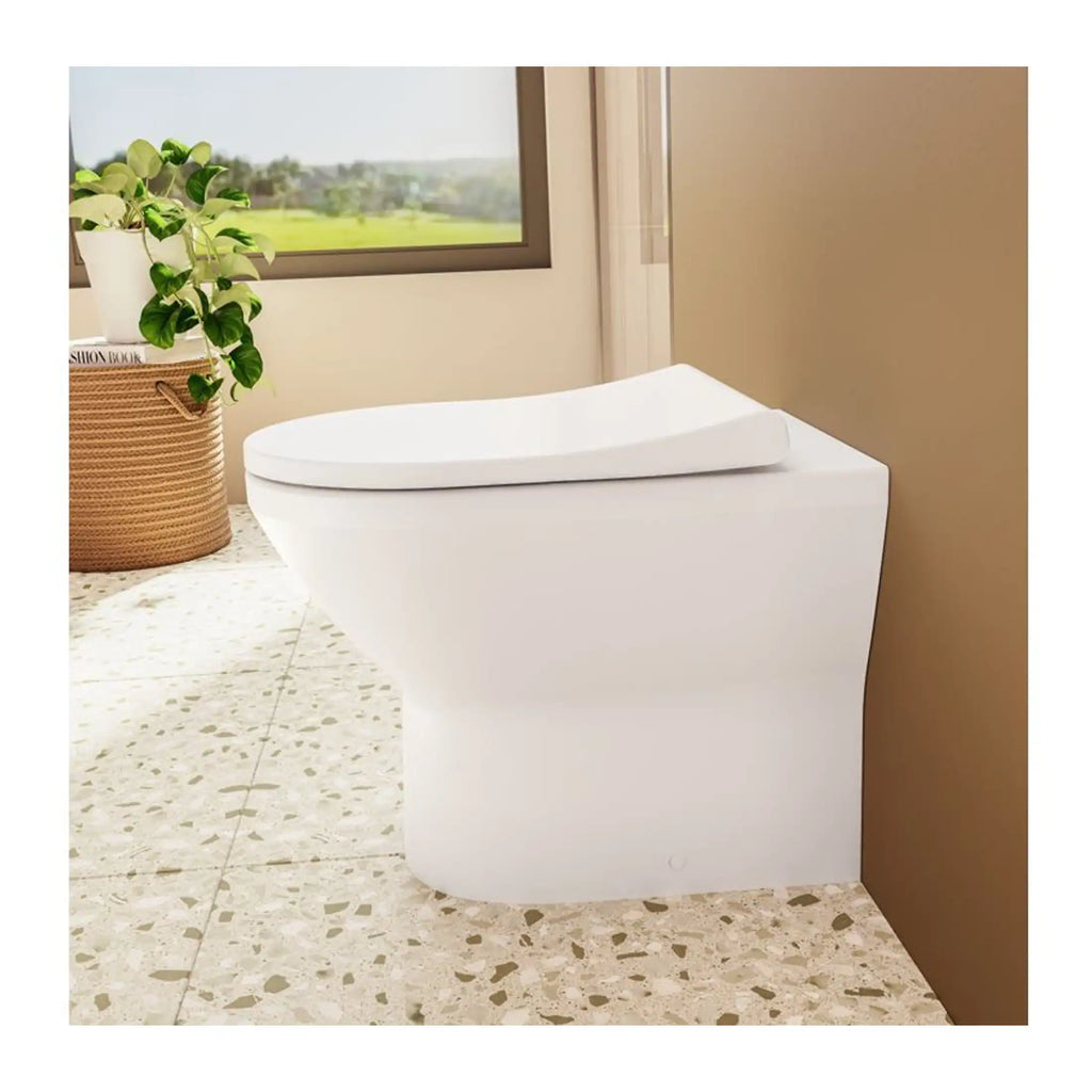 Sleek white modern toilet in a contemporary bathroom with natural light, terrazzo flooring, and decorative plant, showcasing stylish bathroom fixtures and design.