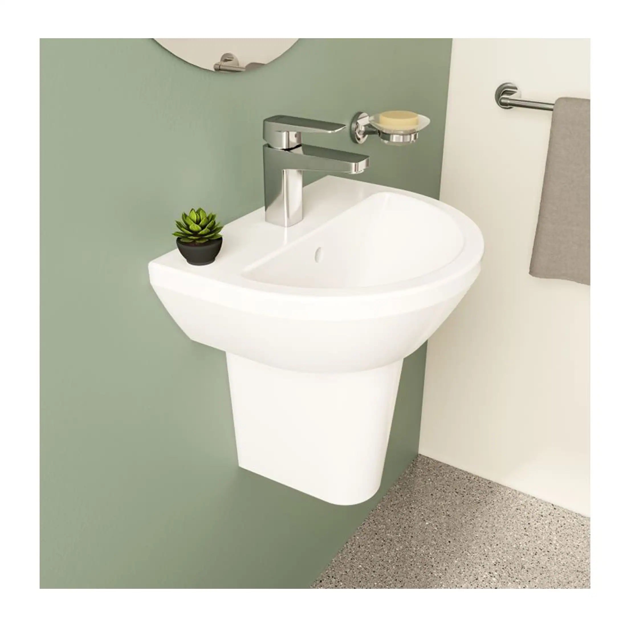 Modern white wall-mounted bathroom sink with chrome faucet, small potted plant, soap holder, and grey towel on chrome rail, in a contemporary bathroom setting.