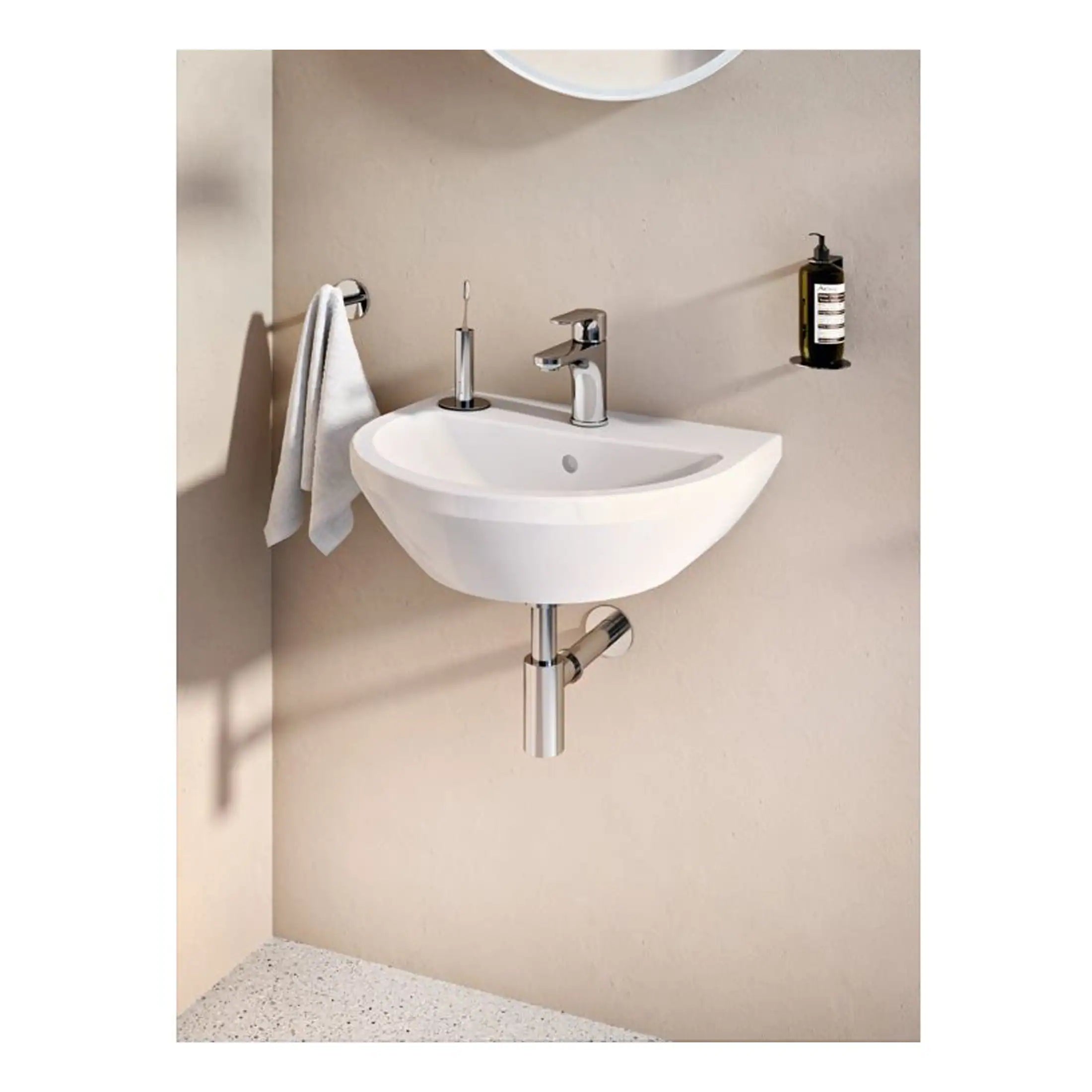 Contemporary wall-mounted white bathroom sink with chrome fixtures, a towel rail, and a soap dispenser for modern bathroom decor.