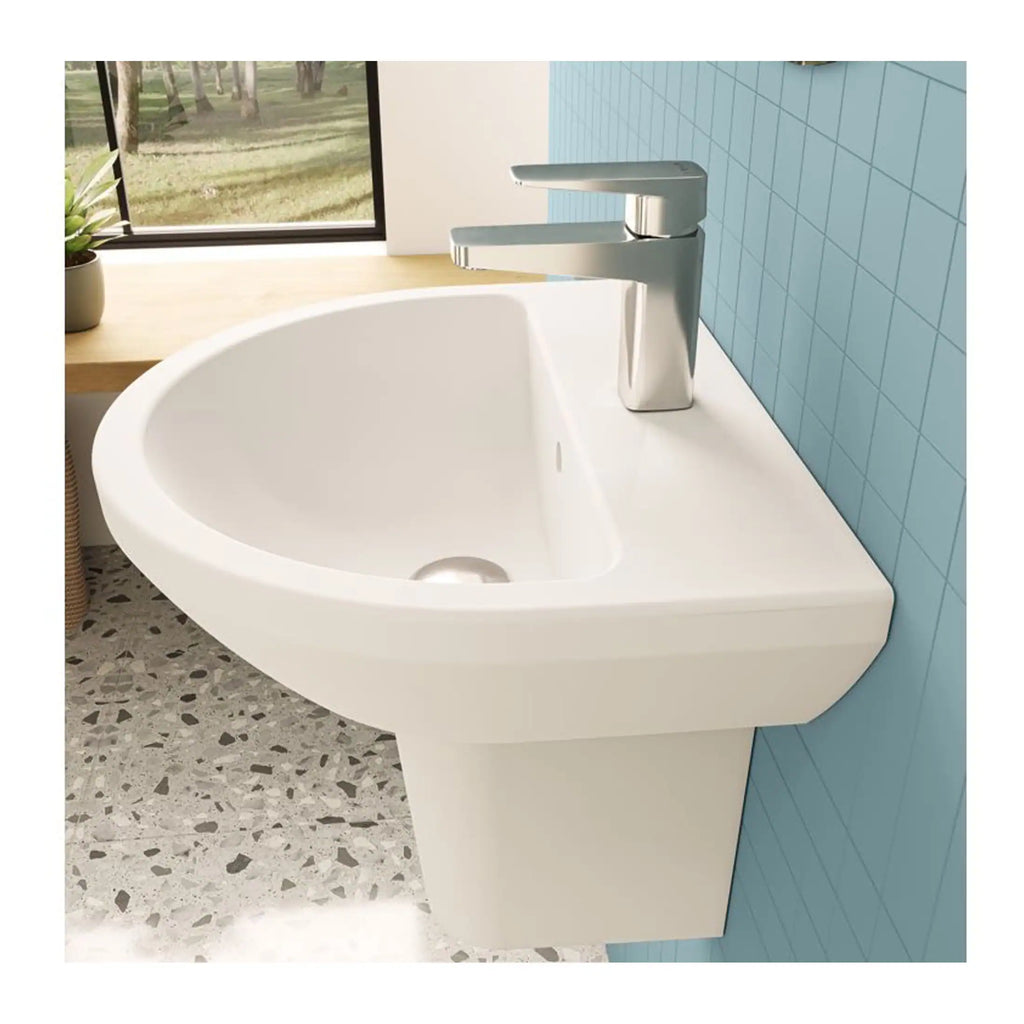 Modern white bathroom sink with chrome faucet, mounted on a minimalist vanity against a light blue tiled wall, in a contemporary bathroom setting.