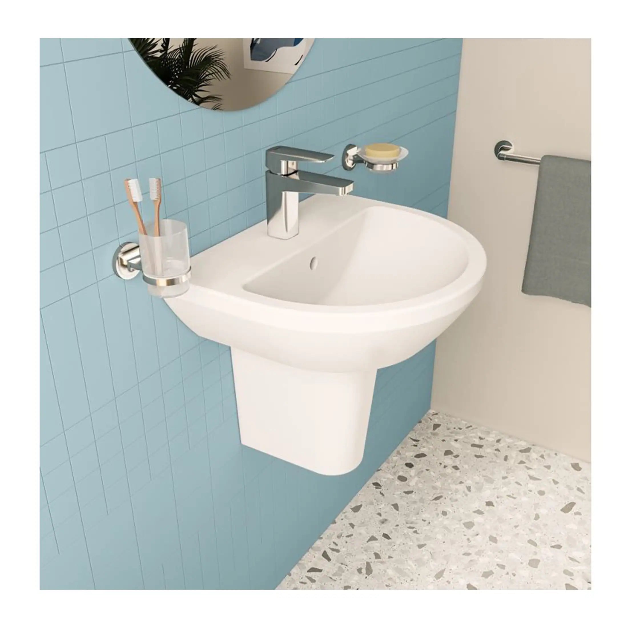 Clean modern bathroom sink with chrome taps, toothbrush holder, soap dish, mirror, towel rail, and terrazzo-style flooring, featuring blue tiled wall.